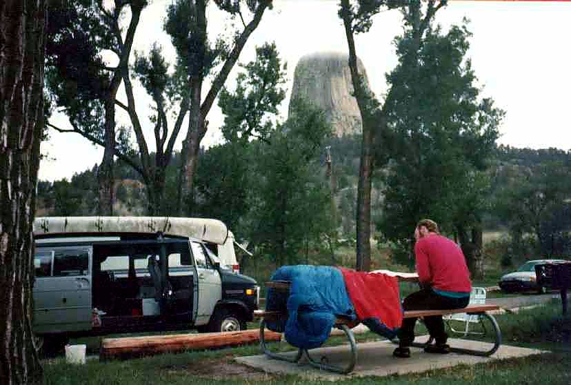 A campsite and vehicle below Devil's Tower.
