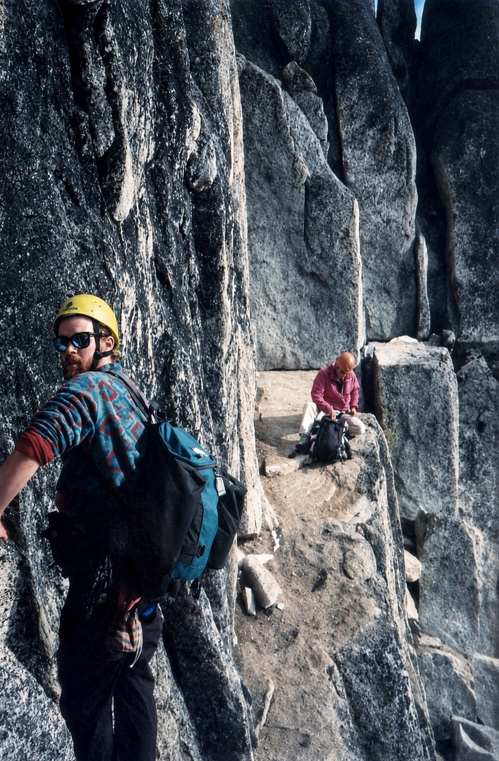 Tim standing on a narrow granite ledge among steep walls.