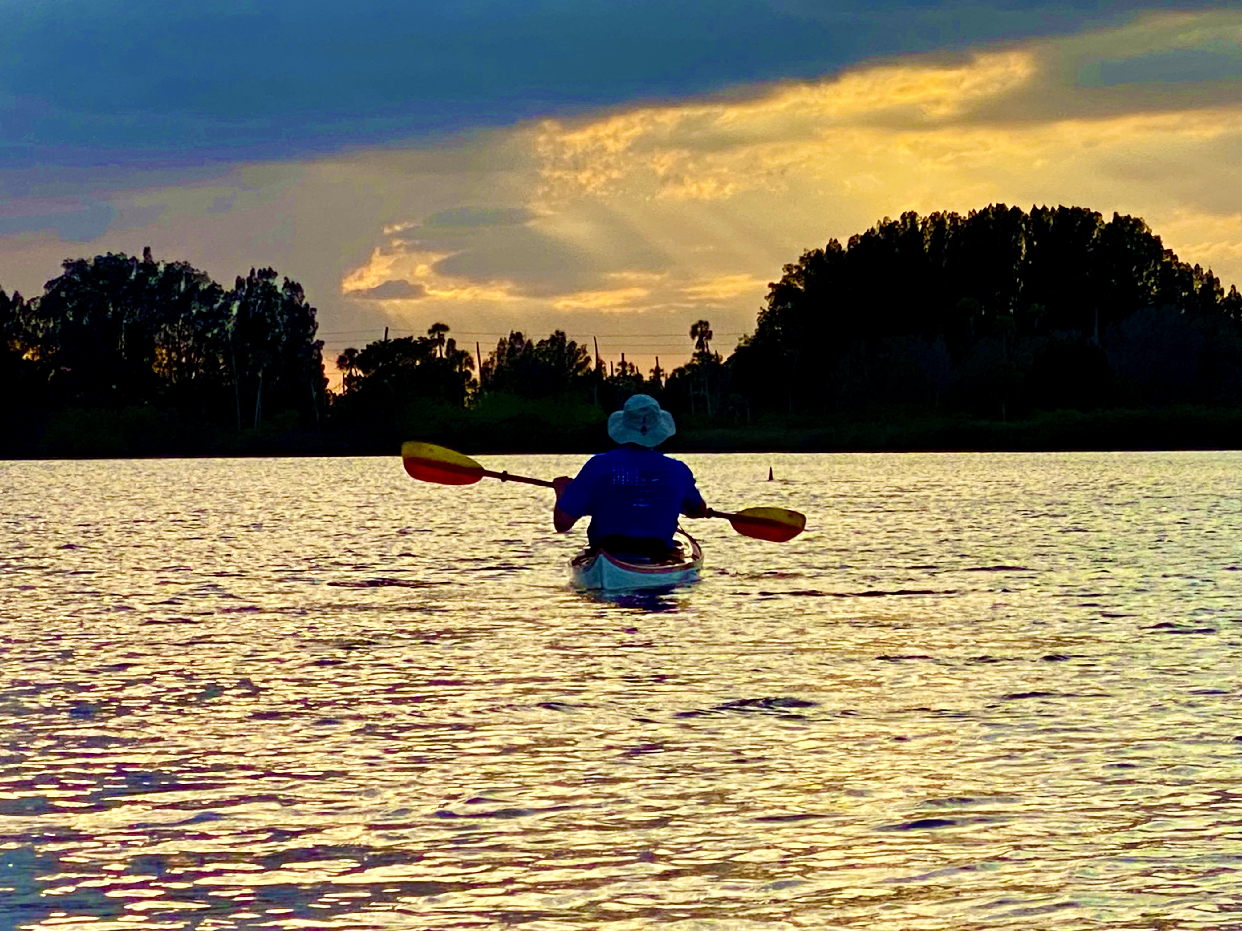A kayaker silhouetted in evening light near Aripeka