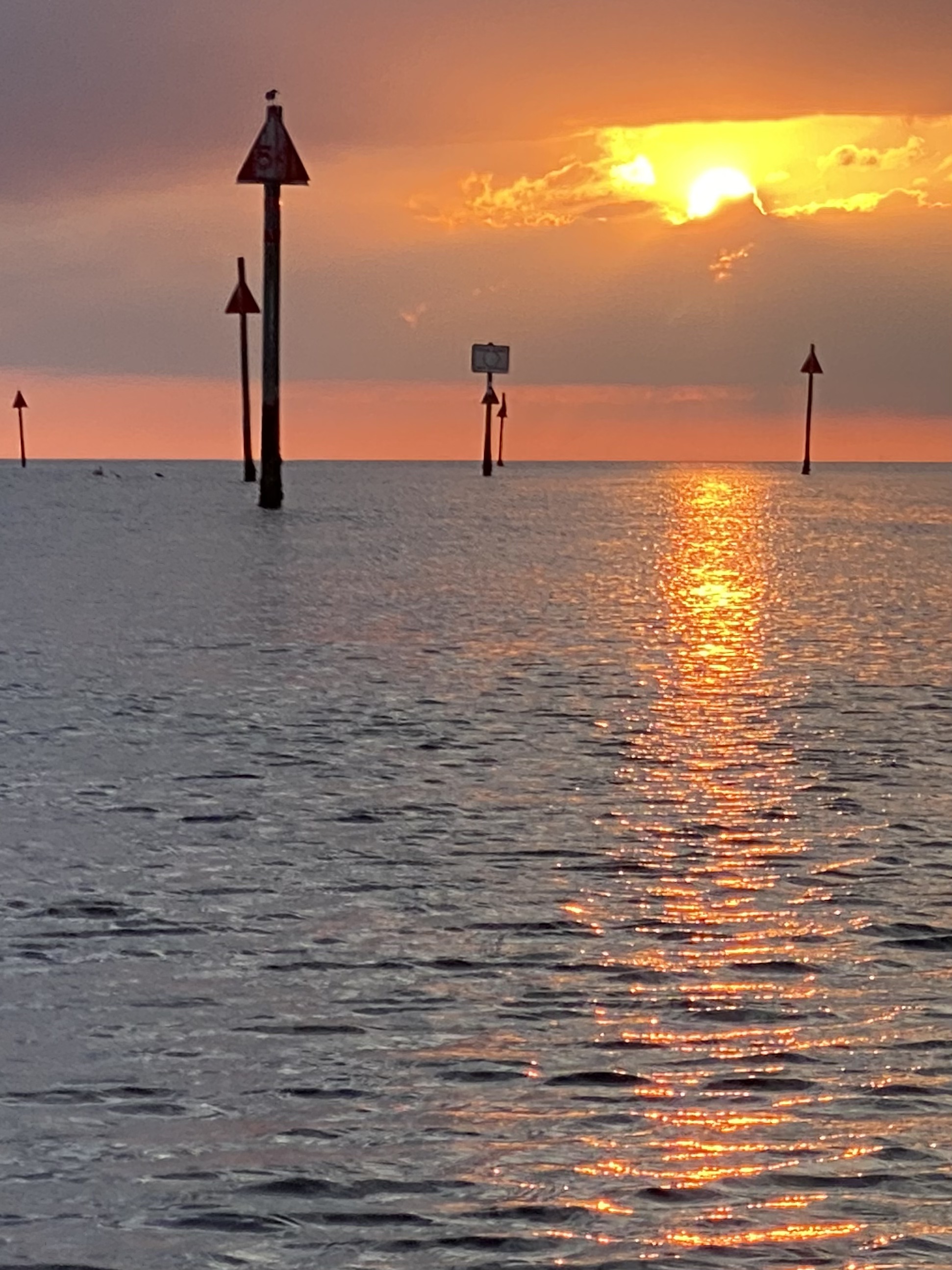 A channel marker silhouetted against the sunset
