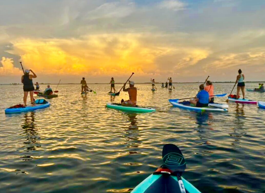 Pinellas Paddlers crossing calm water at sunset
