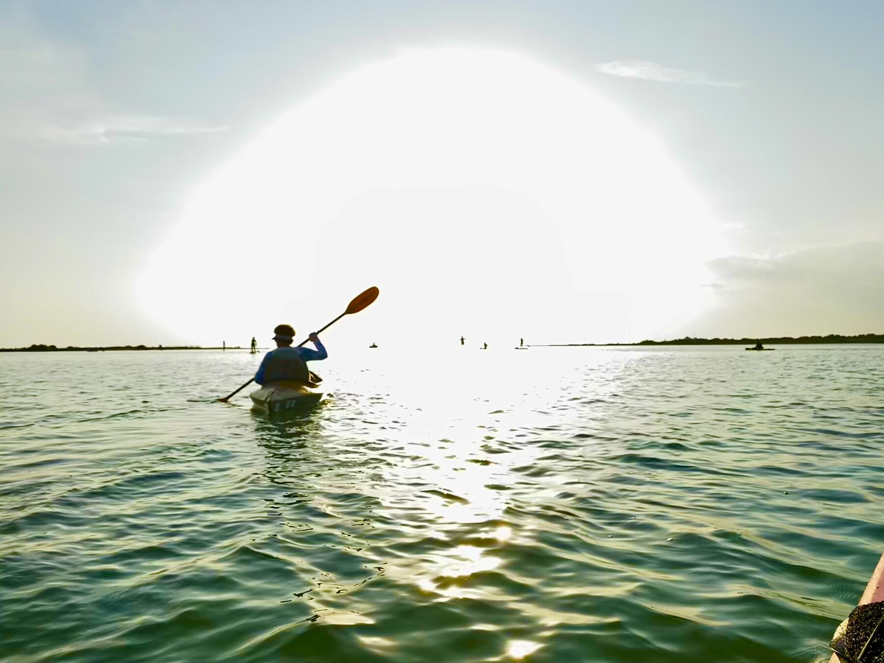Kayaker paddling into bright sunlight
