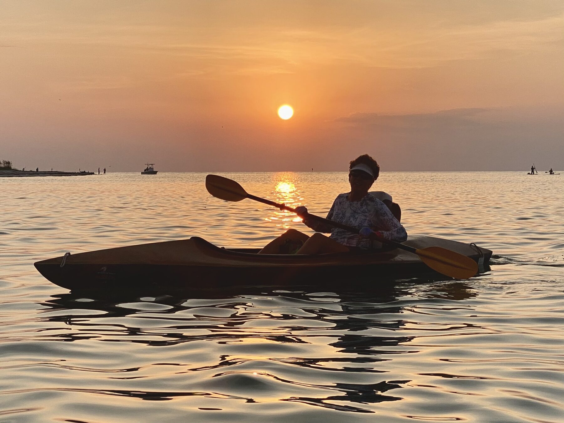 Kayaker and orange sun