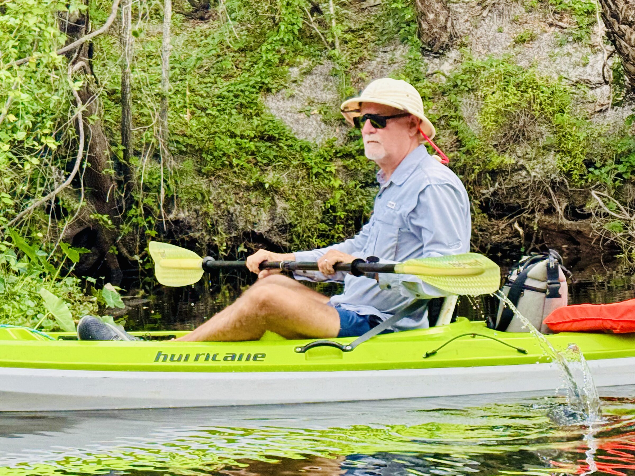 Paddler wearing a hat in a green kayak