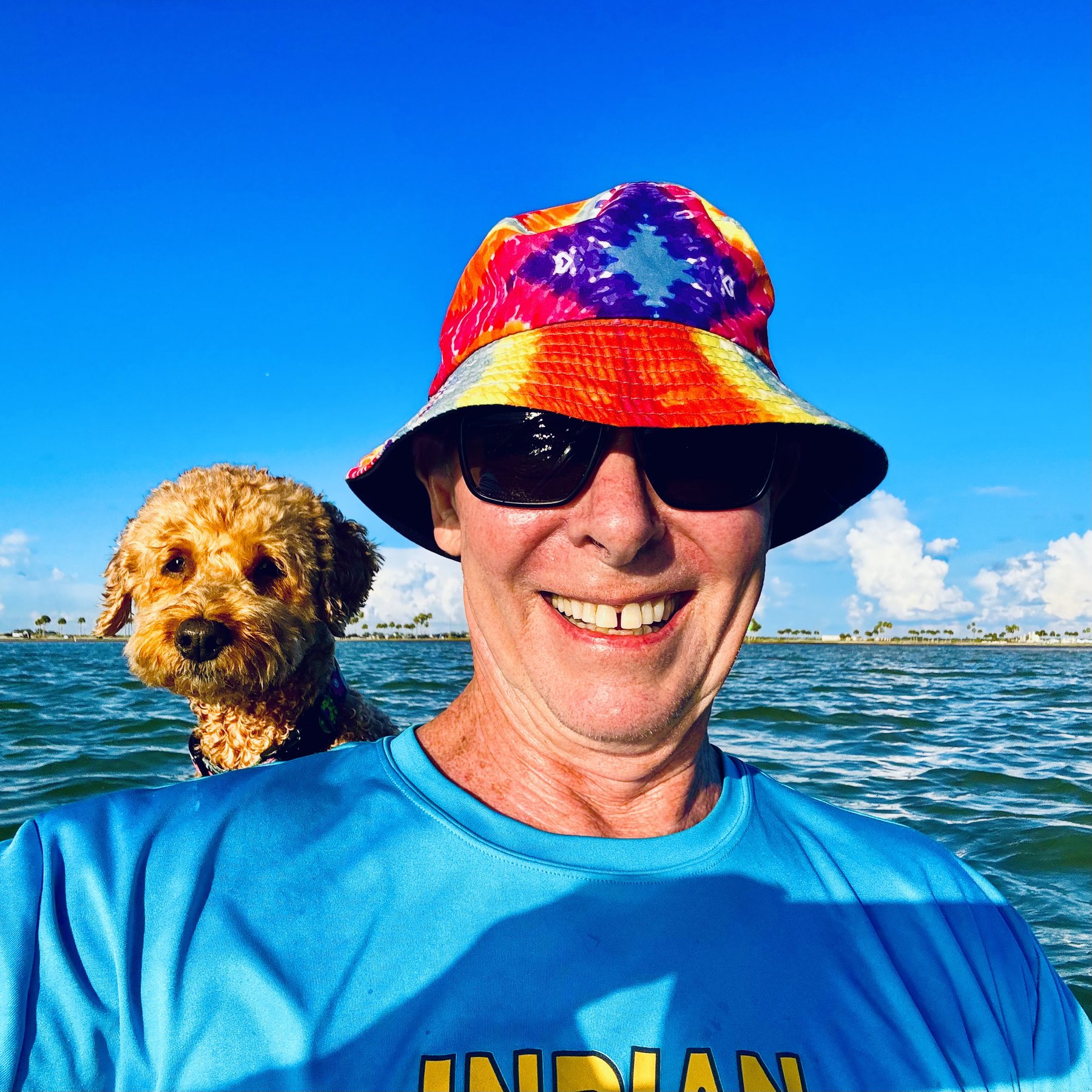 Photo #5: Buddyboy peeking over Tim’s shoulder beneath a brilliant blue sky
