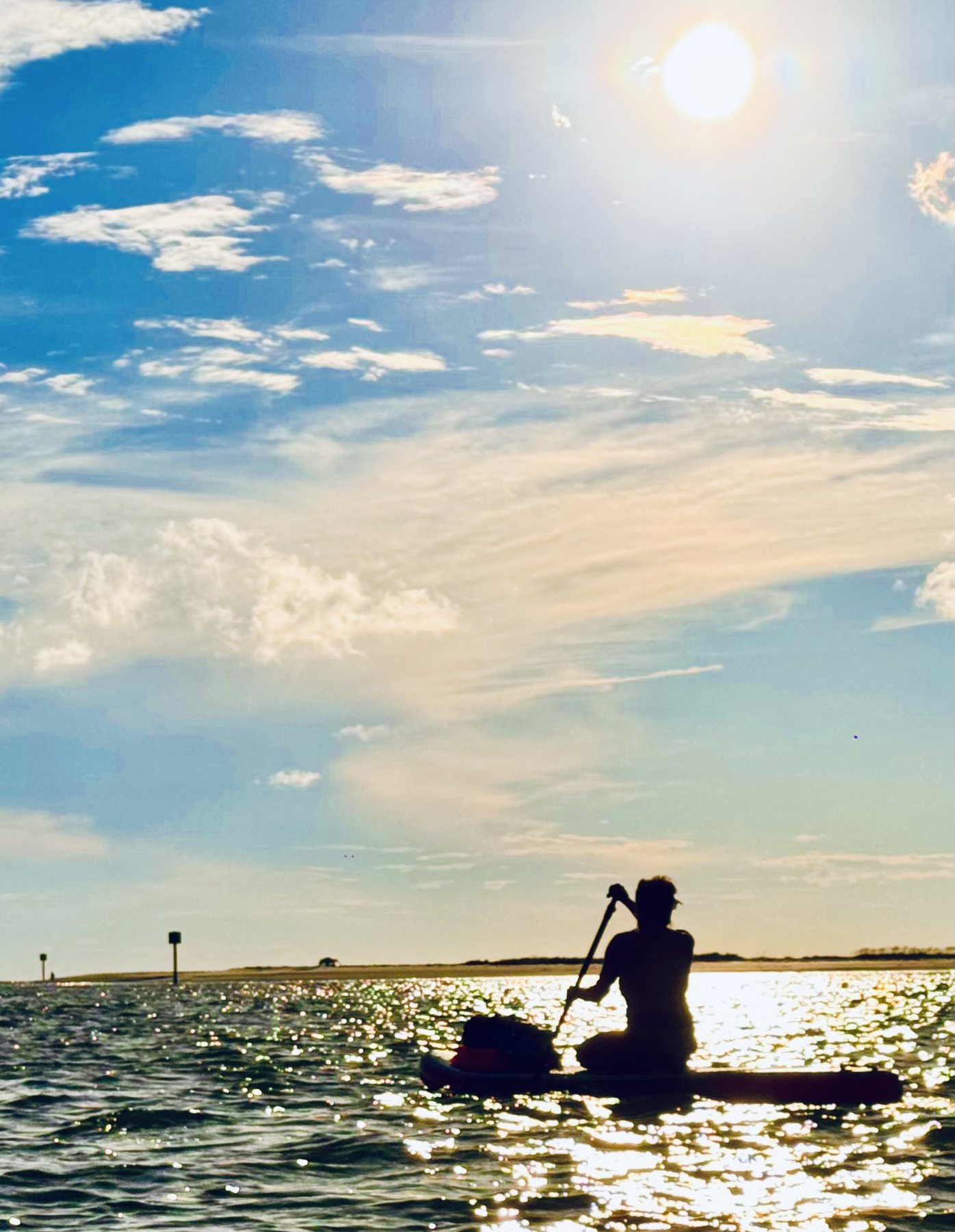 Photo #6: A stand-up paddler silhouetted beneath the late-afternoon sun