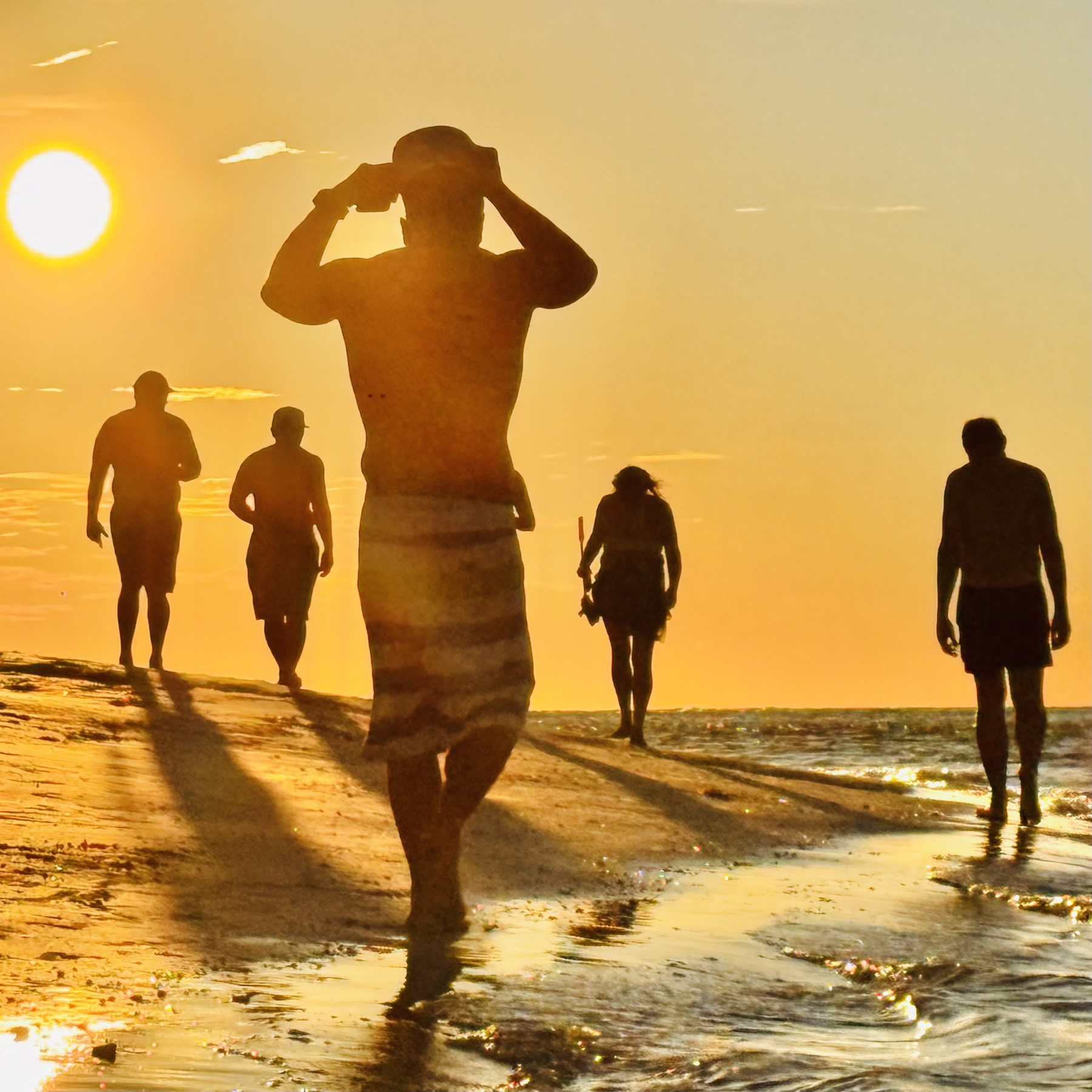 Photo #11: The group walking through shallow water toward the sunset