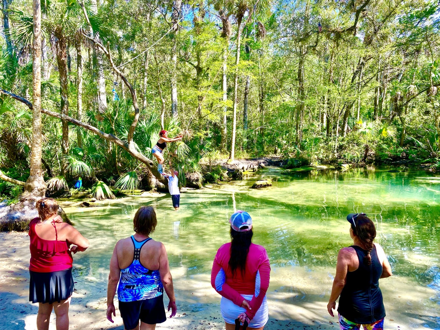 Part of the birthday group gathered at the edge of a spring run beneath the forest canopy.