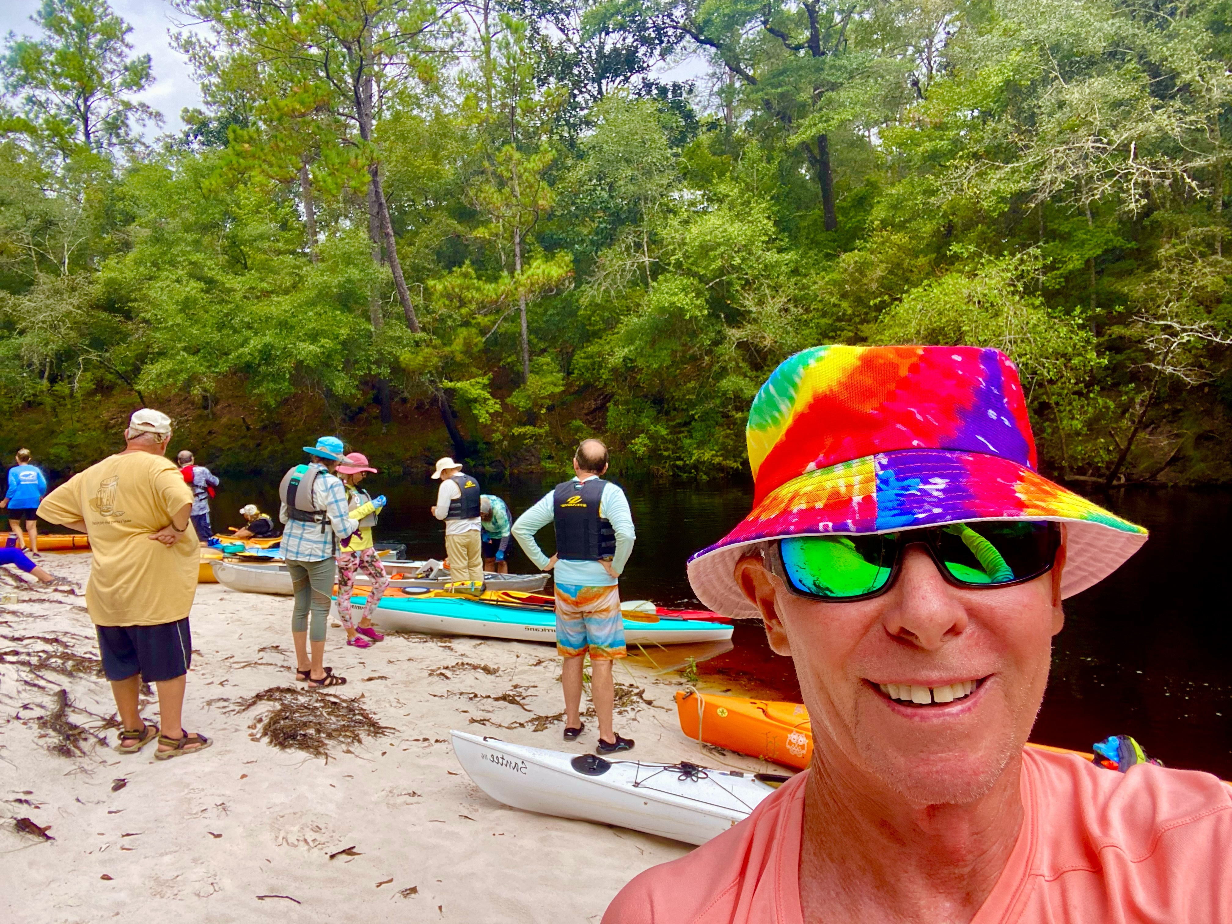 Tim taking a selfie with paddlers and kayaks gathered on a Sopchoppy River sandbar