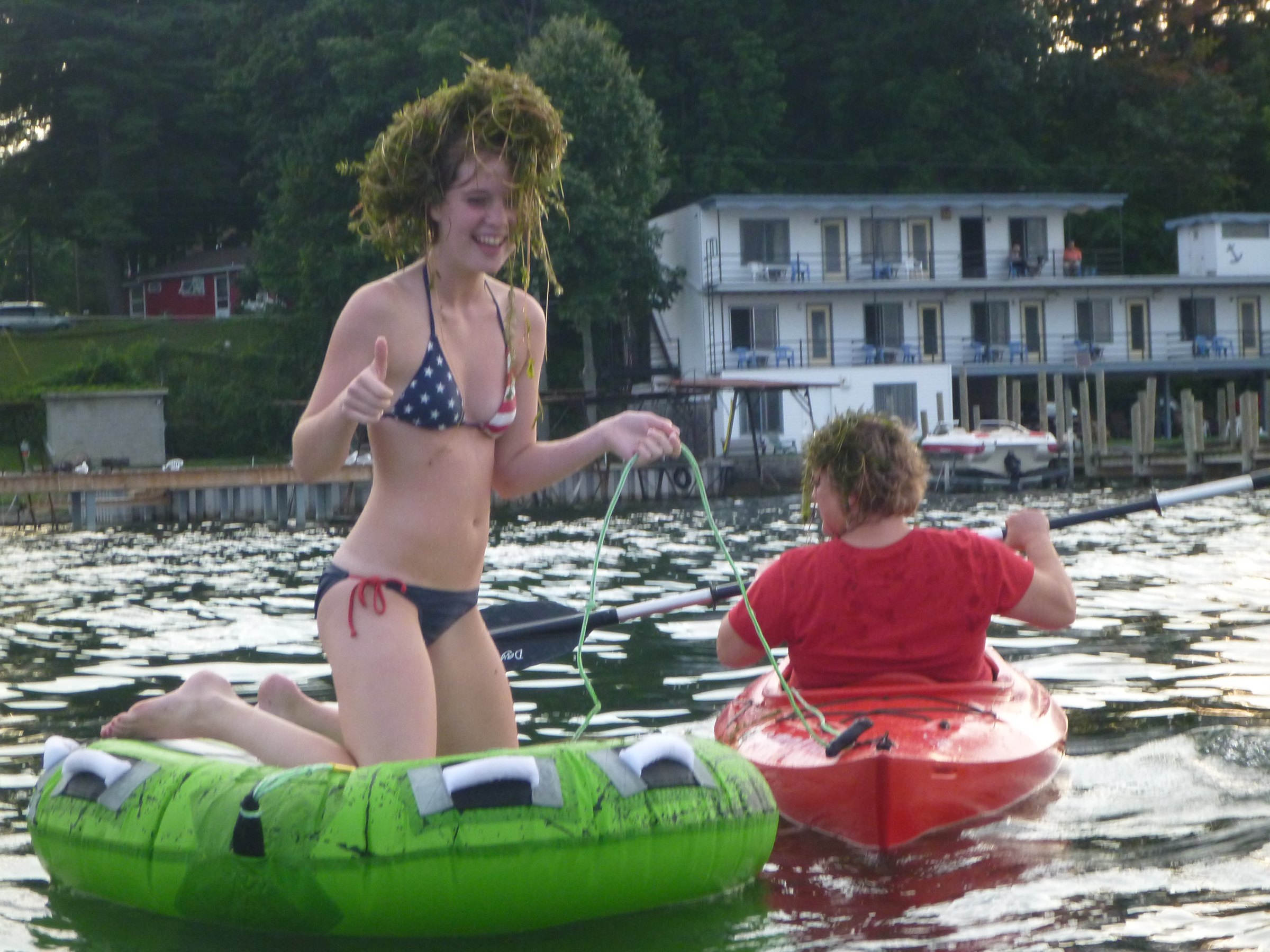 Playing on the raft beside the kayaks.