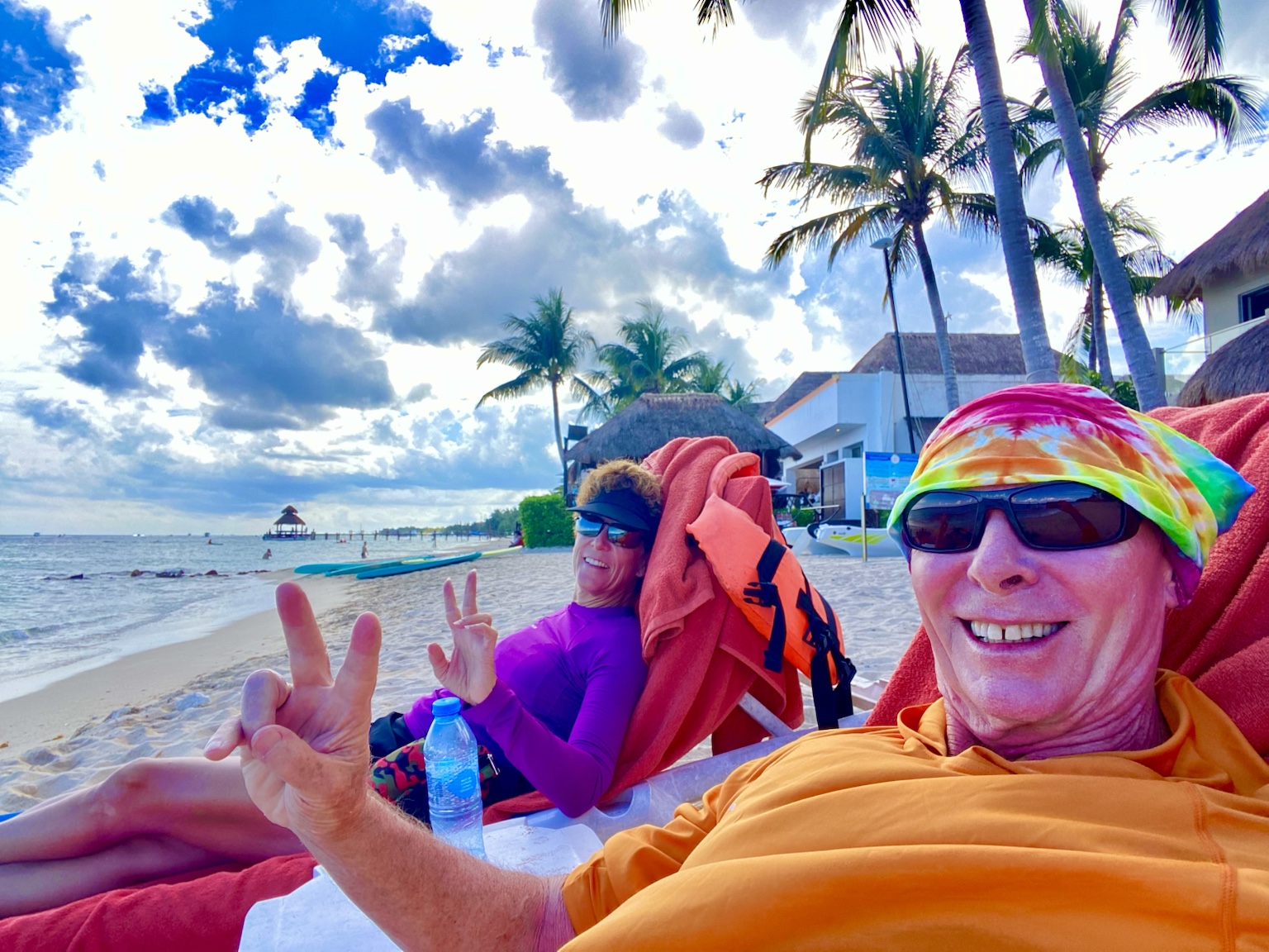 Relaxing in beach chairs beneath the palms during a sunny tropical getaway.