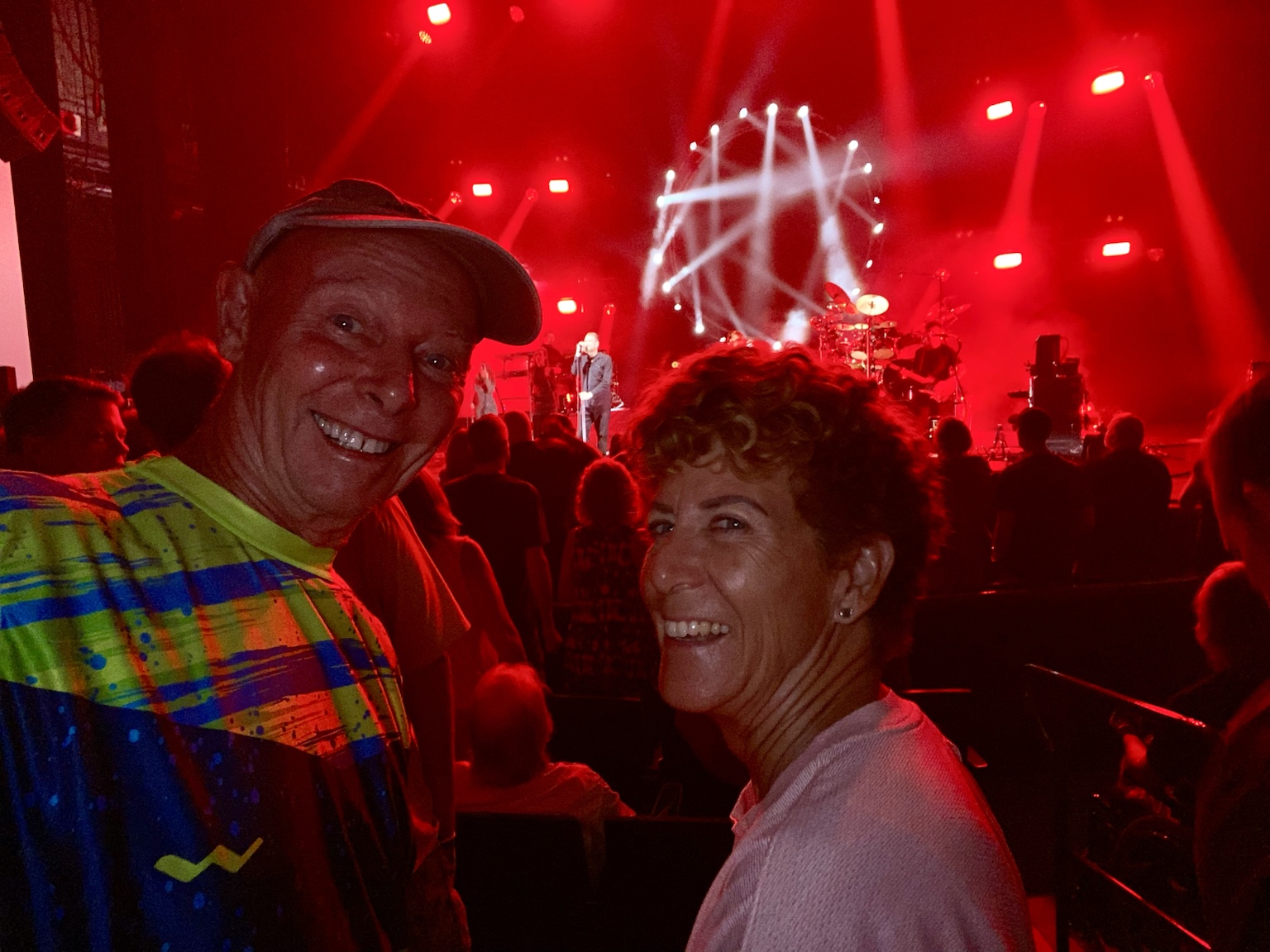 Tim and Kym at a concert beneath intense red stage lighting.