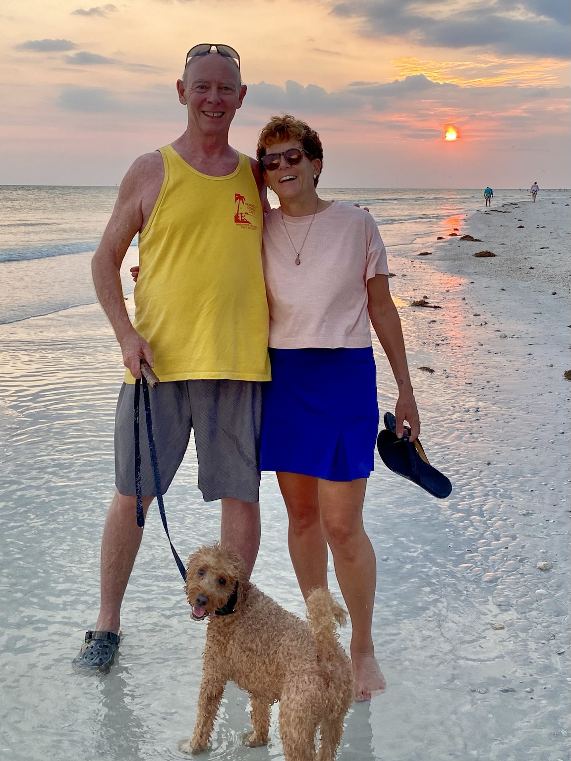 Tim, Kym, and Buddyboy together on the beach at sunset.