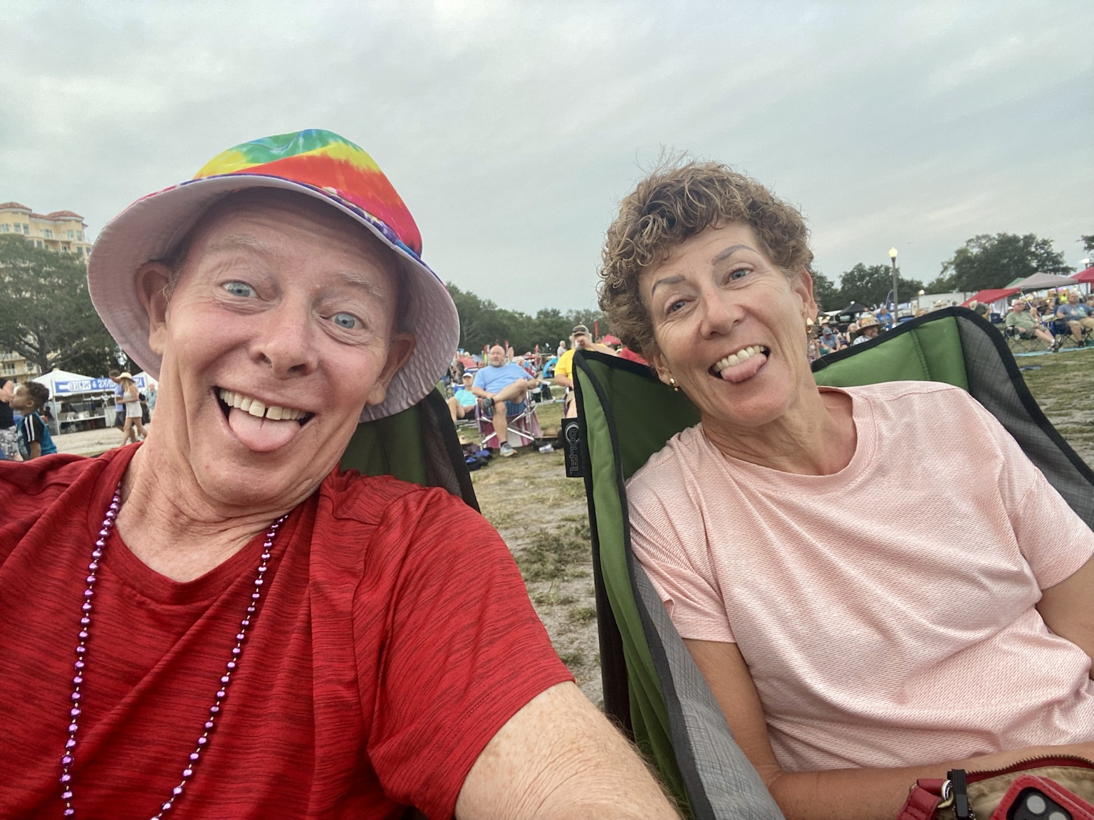 Being silly together from their camp chairs at an outdoor festival.