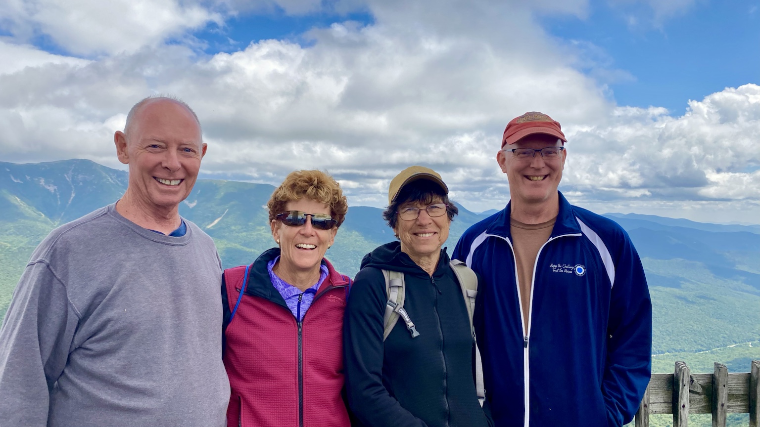 A mountain-top group photo with friends and sweeping ridgeline views.