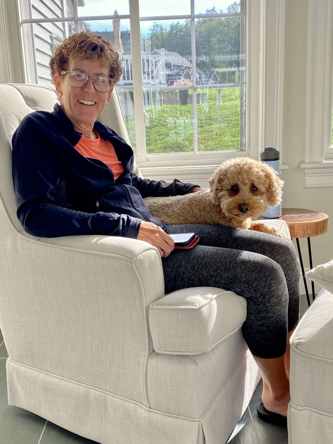 Kym and Buddyboy sharing a quiet moment in a sunlit chair.