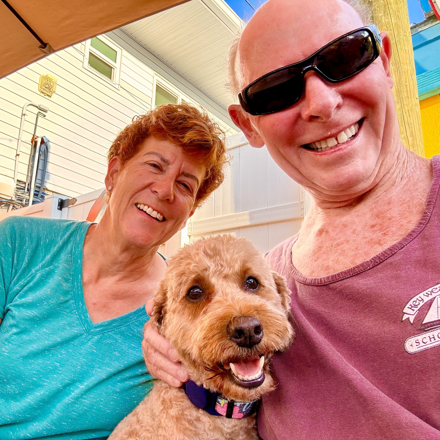 A happy family close-up with Buddyboy between Tim and Kym.